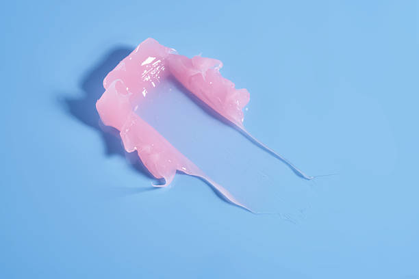 istock The texture of a pink lip mask or balm on a blue background. 2206830457