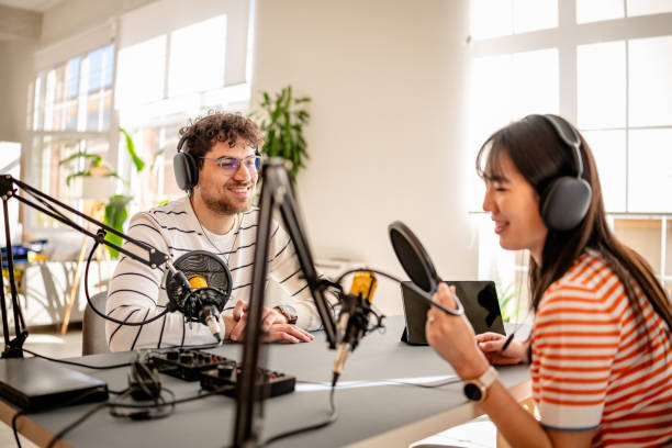 istock Podcast hosts engaging in lively discussion during recording session in a modern studio environment 2206834150