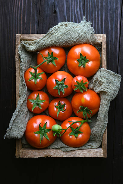 istock Top view on wooden box filled with ripe red tomatoes 2206836617