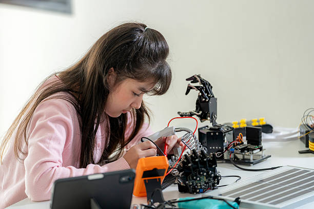 istock An elementary-age girl carefully inspects a robotic arm using a screwdriver in a STEM-focused science classroom. This hands-on learning experience fosters curiosity, creativity, and technical expertise in robotics, engineering, and innovation 2206837576