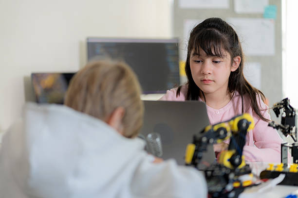 istock An elementary student sits attentively in a classroom, learning from a science teacher how to operate a robotic arm using a remote control. This engaging STEM lesson promotes curiosity, robotics, and artificial intelligence, inspiring the next generation 2206837594