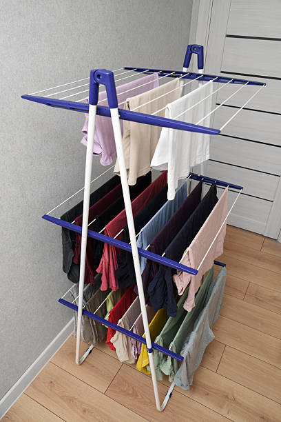 istock Clean clothes on the white three-tiered dryer in the apartment. 2206837749