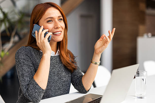 istock Smiling Businesswoman Talking on Phone in Modern Office Setting 2206841515