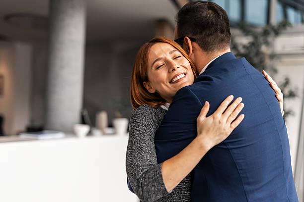 istock Two Smiling Individuals Embracing in a Modern Office Setting 2206841988