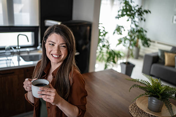 istock Happy woman drinking coffee in modern kitchen 2206842275