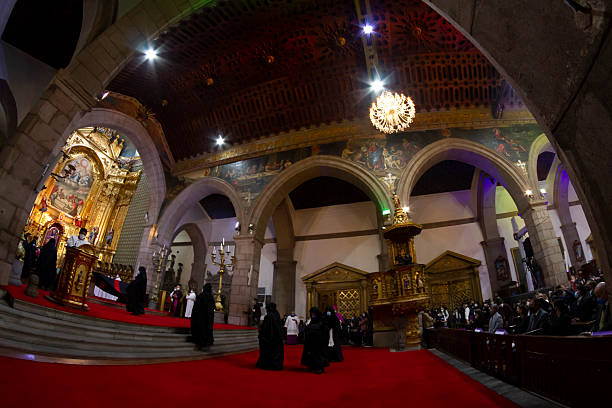 Quito, Pichincha, Ecuador - April 13, 2022: Priests walking on a vibrant red carpet during the Arrastre de Caudas ceremony inside the Metropolitan Cathedral of Quito, Ecuador, celebrating the rich traditions of Holy Week.

The 