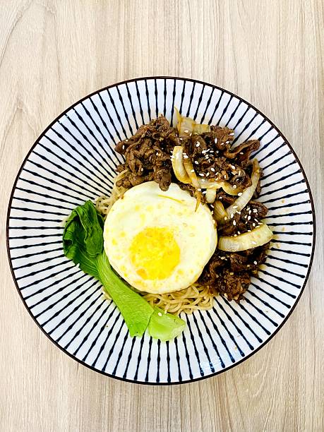 A bowl of noodles with teriyaki beef topping
