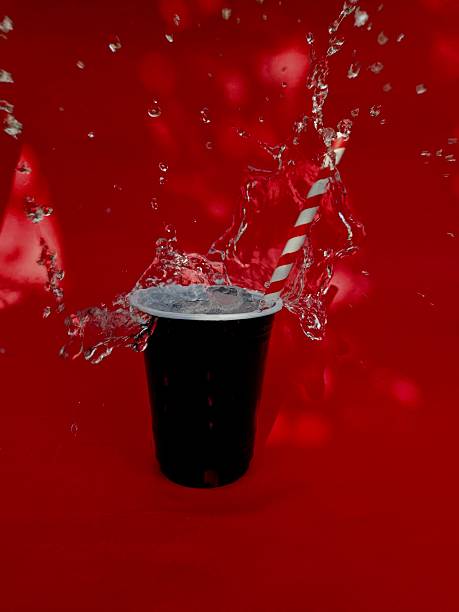 Glass of cola with ice cubes and straw isolated on white background