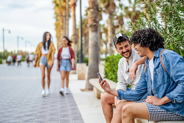 istock Friends Enjoying a Sunny Stroll And Sharing Moments By The Palm-lined Pathway 2206849444