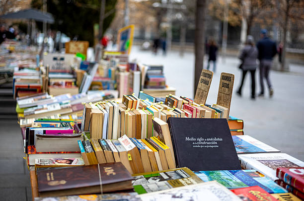 Views of the historic book stalls in Madrid, Spain.  Next to the Botanic Gardens lies a small pedestrian street called Cuesta de Moyano.  this street contains 30 book stalls which are open every day of the week and date back to 1925.  The stalls are now run by the children and grandchildren of the book fair's founders.  The books offered range from philosophy, literature, art , essays, antique comic books, and out of print volumes.