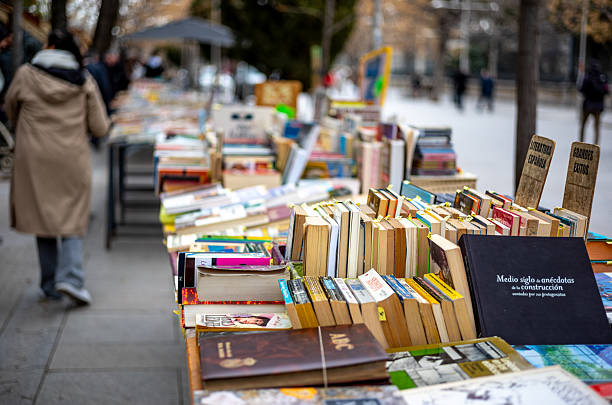 Views of the historic book stalls in Madrid, Spain.  Next to the Botanic Gardens lies a small pedestrian street called Cuesta de Moyano.  this street contains 30 book stalls which are open every day of the week and date back to 1925.  The stalls are now run by the children and grandchildren of the book fair's founders.  The books offered range from philosophy, literature, art , essays, antique comic books, and out of print volumes.