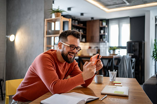 istock Happy freelancer playing mobile game at home office 2206852009