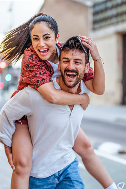 istock Cheerful Couple Sharing a Playful Moment Outdoors in a Vibrant Urban Setting 2206853682