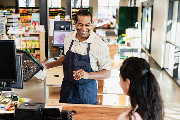 istock Happy grocery store worker helping customer at checkout 2206856188