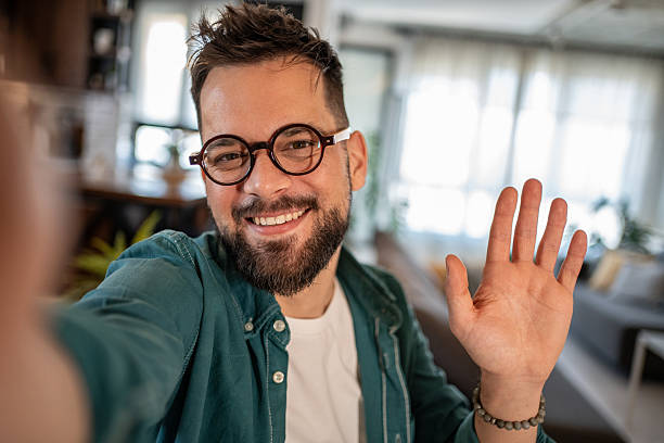 istock Young man making a video call from home and waving 2206857873