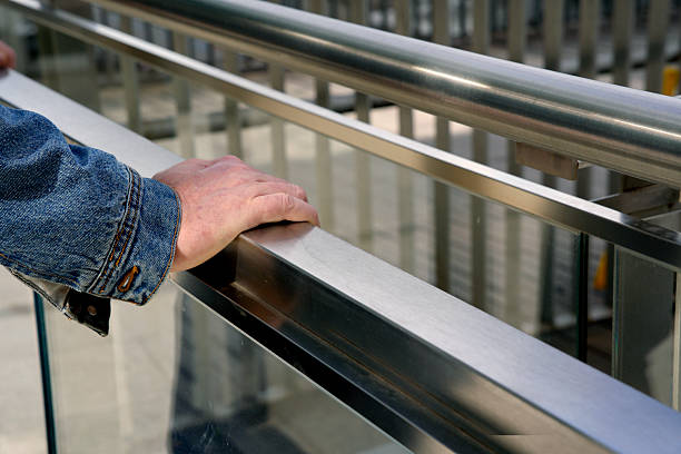 istock Worker resting hand on metal railing of modern building 2206858100
