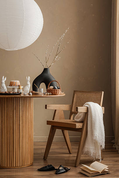 istock A refined Easter breakfast setup featuring a wooden dining table, a rattan chair, and a black sculptural vase with soft willow branches, creating a sophisticated seasonal atmosphere. 2206858749
