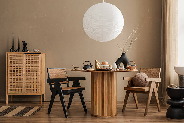istock A contemporary dining room with a sculptural wooden table, statement chairs, and elegant black and gold Easter decorations, blending modern aesthetics with seasonal charm. 2206858776