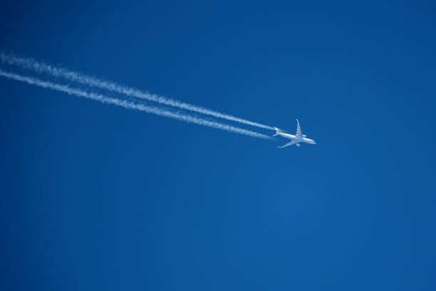 istock Airplane in the blue sky with contrail 2206859711