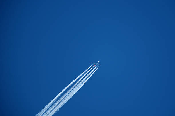 istock Airplane in the blue sky with contrail 2206859713