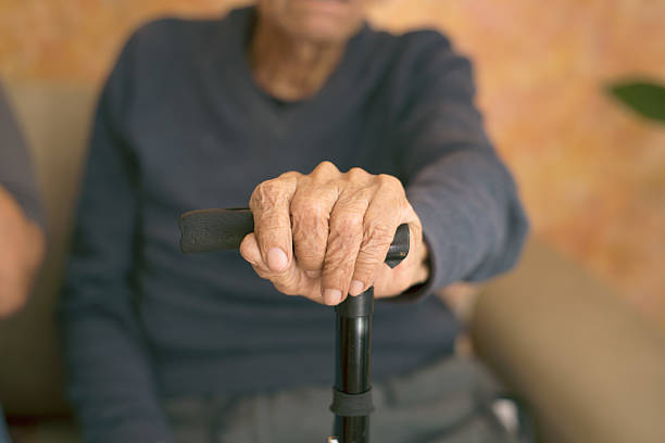 Senior man holding a walking stick, symbolizing aging, mobility challenges, and the need for support in old age