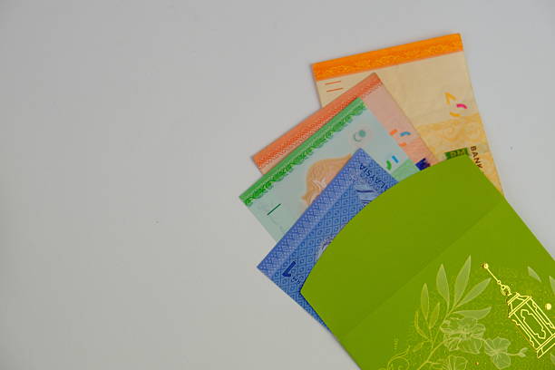 istock Money packet or translated as sampul duit raya in Malay with Ringgit Malaysia Notes for Ramadhan and Eid Fitr Celebration on isolated background. Selective focus. known as Duit raya 2206860734
