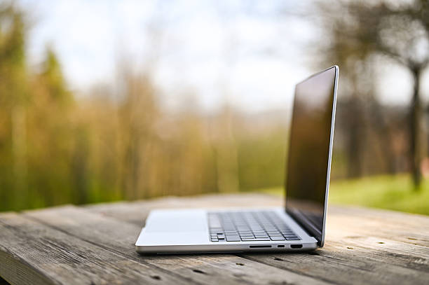 istock Modern laptop computer on wooden table in nature setting 2206861618