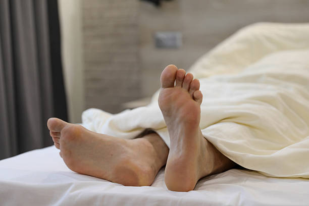 istock Gentle Wake-Up: Relaxed Feet on a Crisp White Bed 2206862108