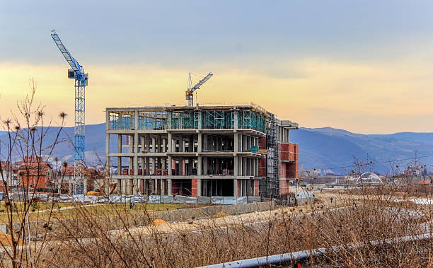 istock A view on a building under construction with cranes and hill in the background. 2206863763