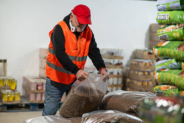 istock An elderly worker in a pet food warehouse cheerfully does his job. 2206863969