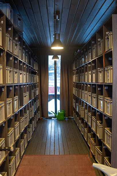 istock Narrow room with numbered boxes and watering can illuminating from hanging lamp 2206864521