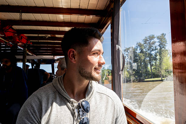 Boat tour on the Parana Delta, Tigre, Buenos Aires, Argentina. Lush vegetation, palm trees, construction site of modern brick house. Lujan River delta system bringing water to Rio de la Plata.