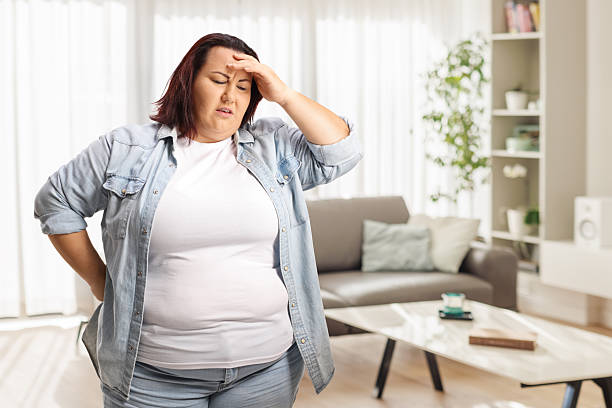 istock Stressed and worried plus size woman holding her head 2206866073