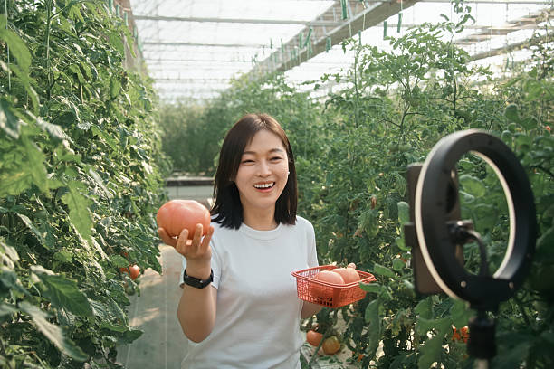 Asian female farmer is live-streaming on her mobile phone