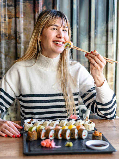 istock Woman eating sushi rolls with chopsticks 2206869586