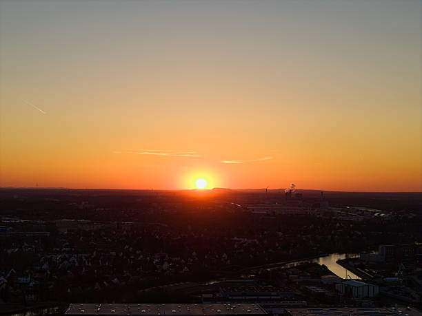A stunning sunset lights up the cityscape and the river below, showcasing serene beauty and tranquility Hannover Wasserturm