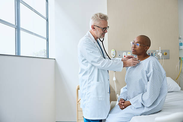 istock Doctor examining female patient sitting on bed 2206871938