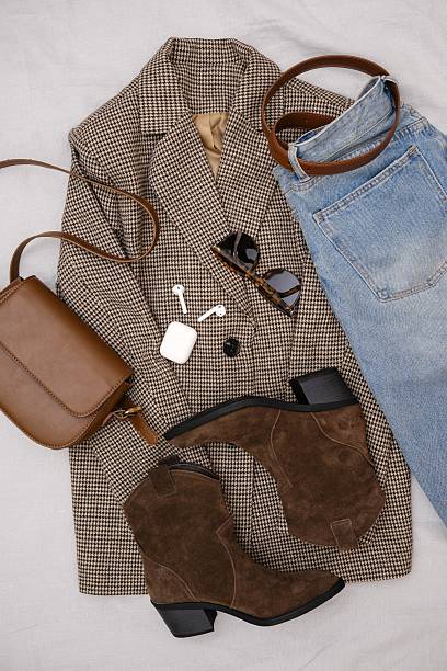 istock This stylish fall ensemble features a chic brown blazer, trendy ankle boots, headphones, jeans and a fashionable dark brown handbag. 2206872391