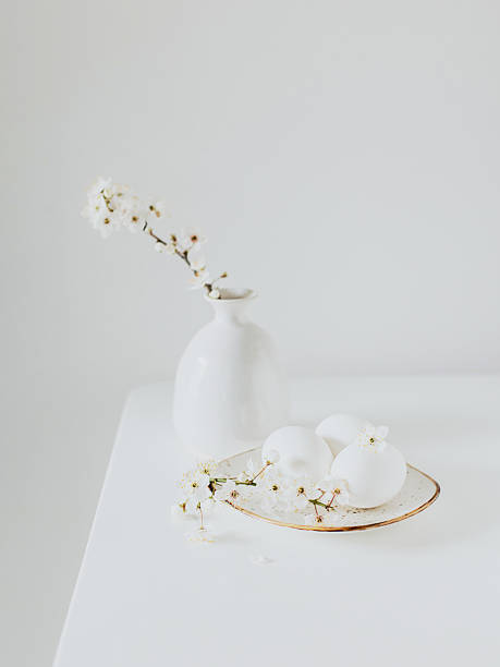 istock Beautiful blossom branches in a vase and eggs on a white background. Spring minimalistic concept. 2206873082