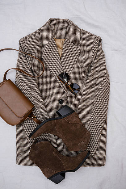 istock This stylish fall ensemble features a chic brown blazer, trendy ankle boots, and a fashionable dark brown handbag. 2206873161