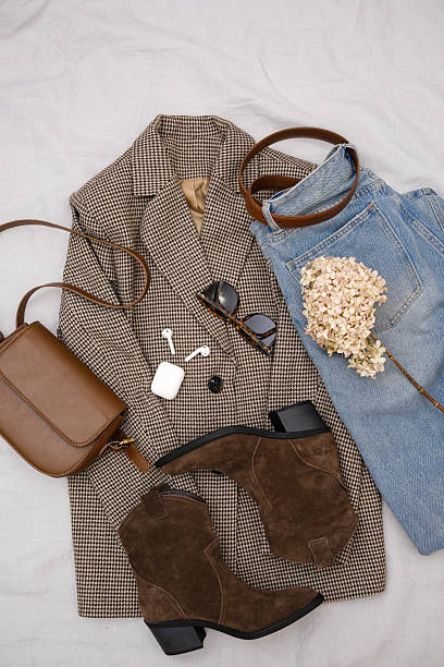 istock This stylish fall ensemble features a chic brown blazer, trendy ankle boots, headphones, jeans and a fashionable dark brown handbag. 2206873222