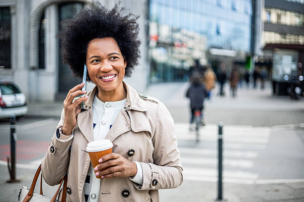 istock Woman talking on the phone while walking in the city 2206875193