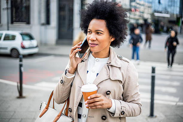 istock Woman talking on the phone while walking in the city 2206875201