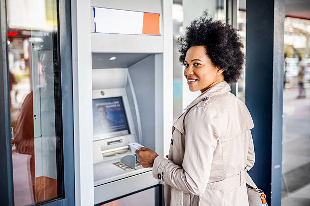 istock Young woman using an ATM 2206875525