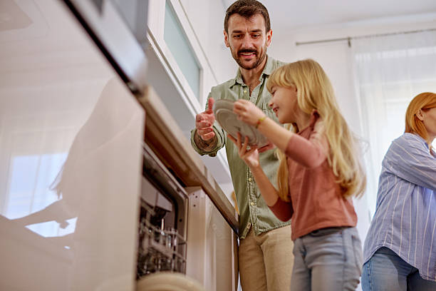 istock Family emptying the dishwasher in a modern kitchen 2206876409