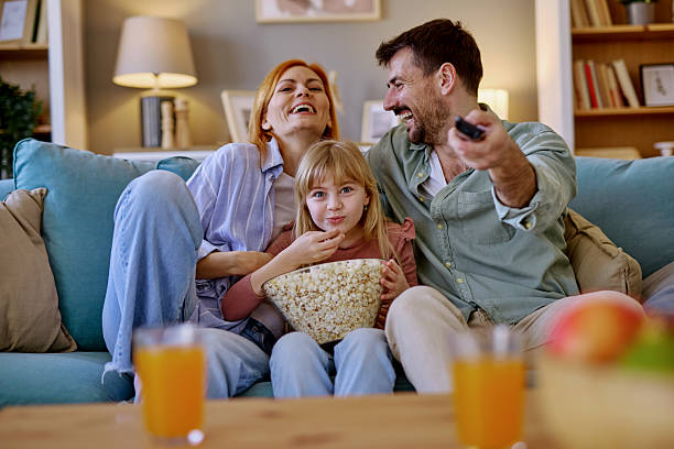 istock Family laughing and eating popcorn while watching TV 2206876528