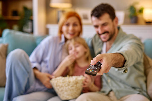 istock Family watching television together and eating popcorn on sofa 2206876529