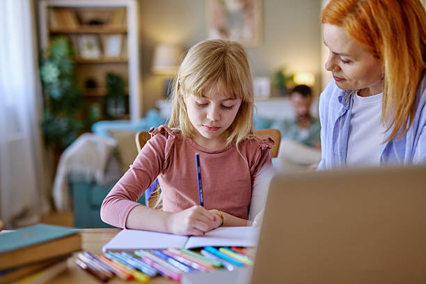 istock Mother helping daughter with homework at home 2206876533