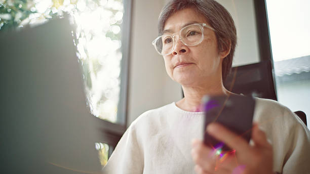 istock Mature woman using laptop and smartphone. 2206877834