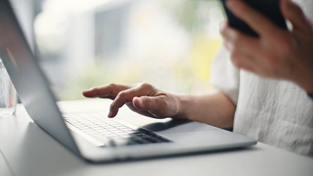 istock Mature woman using laptop and smartphone. 2206877835
